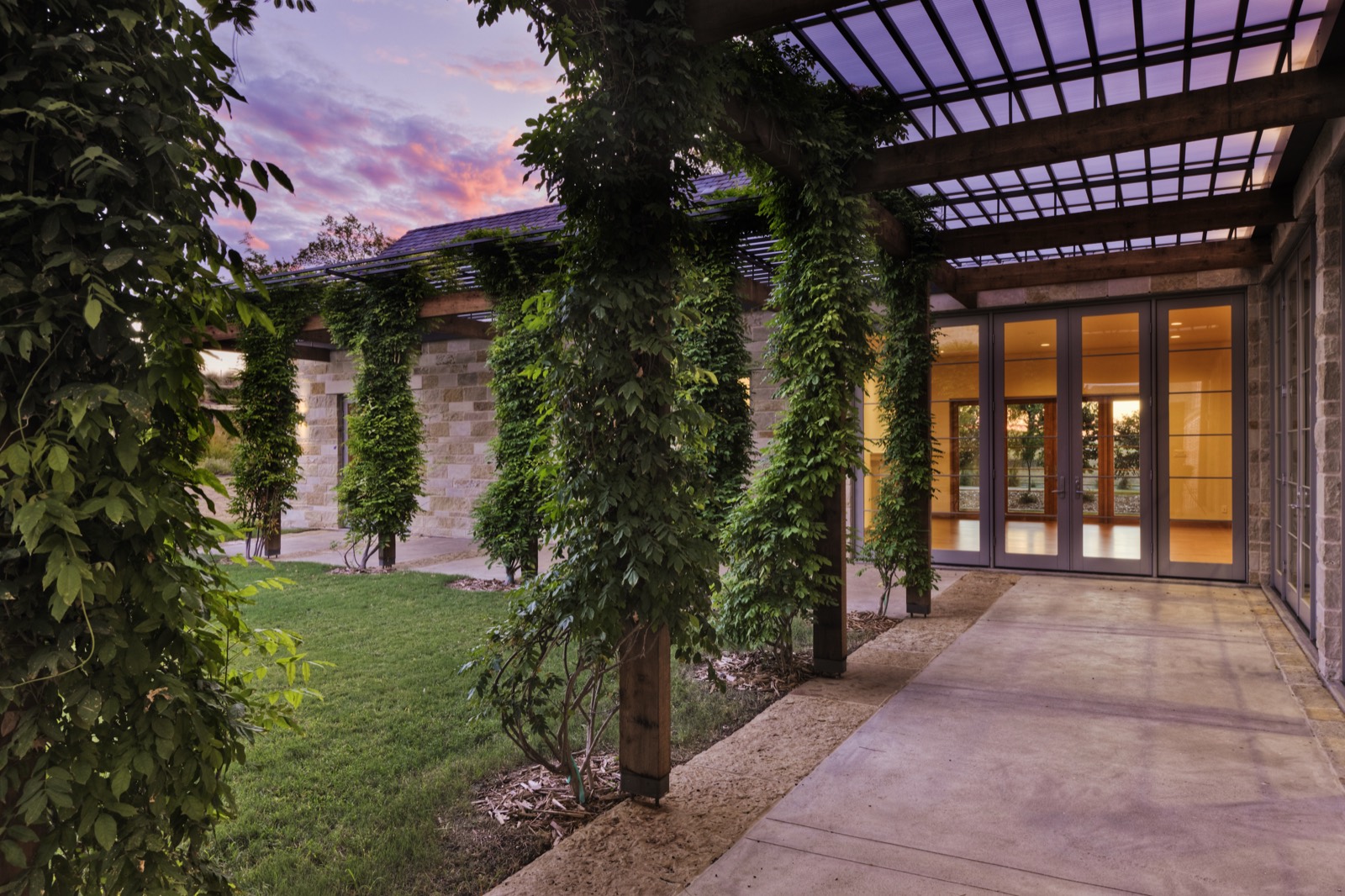 Vine-covered columns along a stone building at sunset